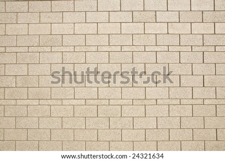 Block wall of tan bricks and straight lines useful for textures or backgrounds.