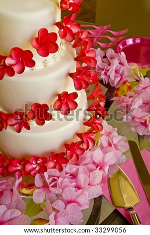 stock photo A wedding cake with red flowers surrounded by pink flowers