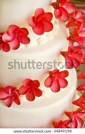 stock photo Closeup of a white wedding cake with red flowers