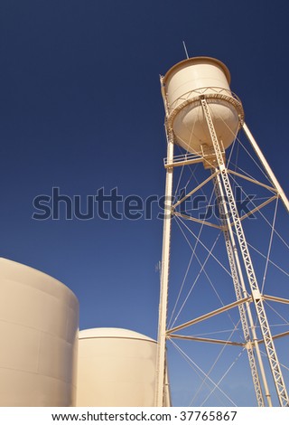 Water storage tanks photographed against a blue sky at sunrise.