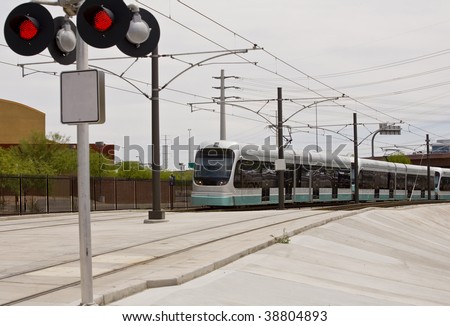 Light rail train of the Phoenix Metro system photographed in Tempe Arizona at a rail road crossing.