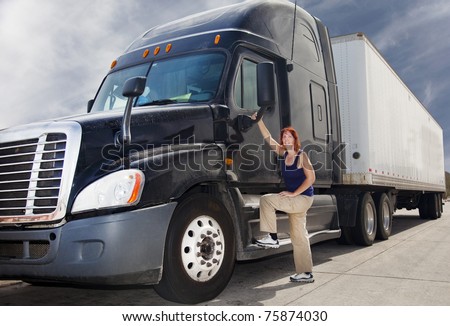 Woman driver at the wheel of her commercial 18-wheeler diesel semi truck.