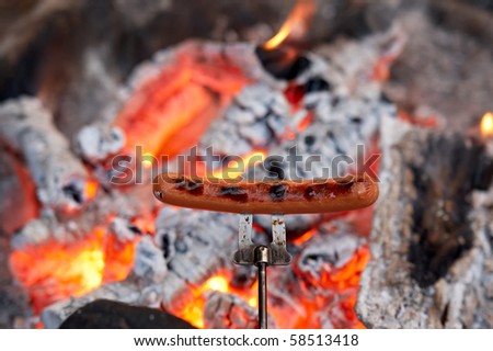 Roasting hotdogs over an outdoor campfire