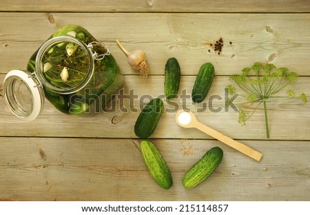 Homemade preserves. Preparation of pickled cucumbers. Fresh cucumbers in the jar and ingredients on the table