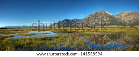 A panorama of Jobs Peak and the surrounding mountains reflecting off of Carson Valley, Nevada.