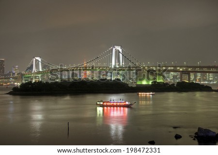 Dinner cruise boats on Tokyo Bay below the Rainbow Bridge and Tokyo Tower at night.