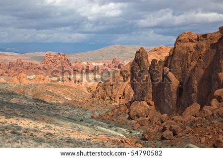 The desert of the Valley of Fire State Park beneath dramatic clouds.