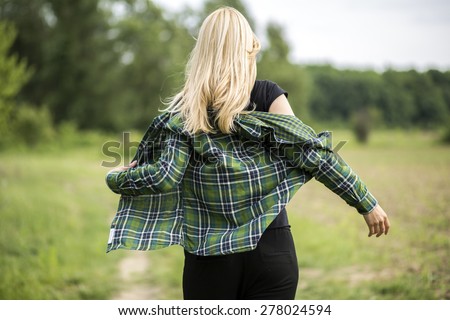 Back view of sexy woman taking off her jacket.