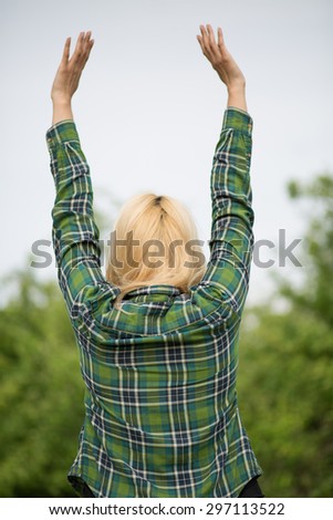 Beautiful blonde woman enjoying nature on the field. Beautiful slim girl Outdoor raising hands. Happy Free Lady.