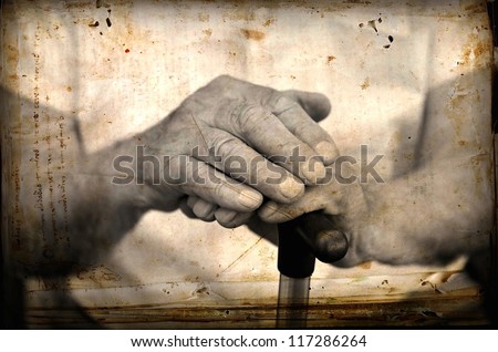 Hands of an old man holding a cane.Photo in old image style..