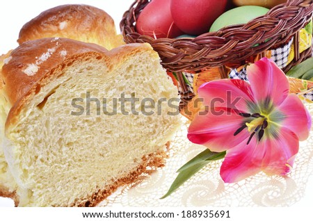 Easter cakes, colored eggs in wicker basket  and tulips on   knitted cover