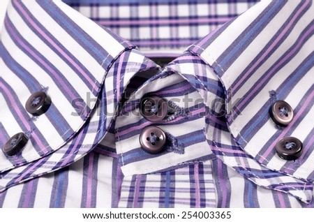 Close-up of buttons on a striped purple shirt
