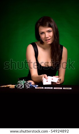 The girl in a black dress with cards on a green background