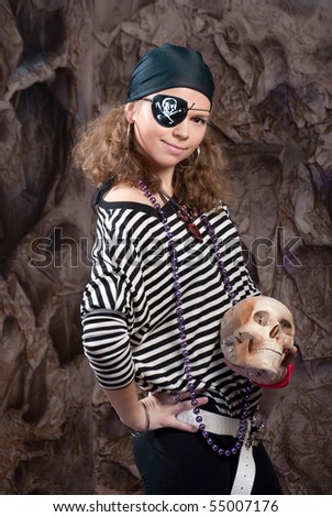 The girl in a suit of the pirate with a skull in a hand