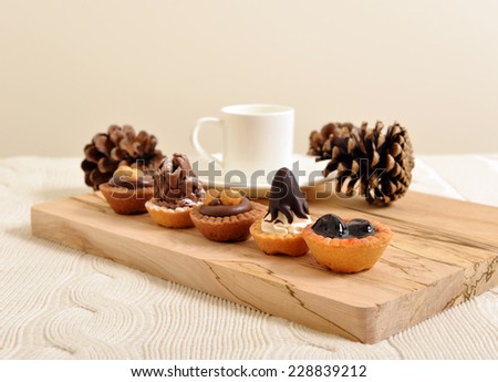 chocolate pastry and bakery with coffee cup and pine cones on a wooden board abstract holiday background