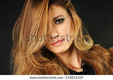 close up portrait of a Young beautiful girl with long blond perfect hair covering half of her face