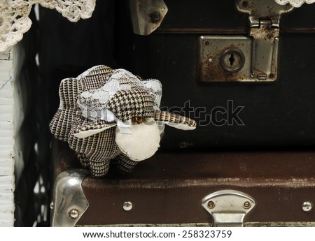 handcrafted woolen sheep decorated with lace on the vintage leather luggage bags with old fashioned locks