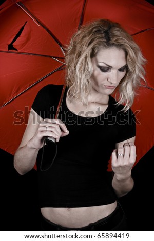 A beautiful blonde girl holding a torn umbrella, having a \