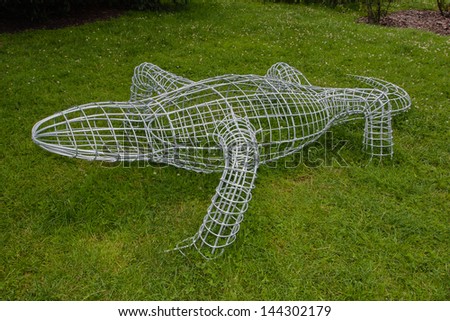 Shaped wire cage used to develop and maintain clearly defined shapes of live perennial plants.