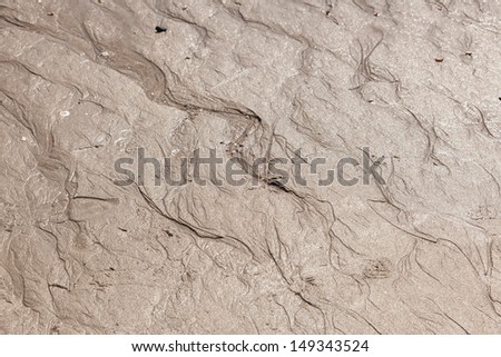 Irregular rippled wet brown sand pattern background.