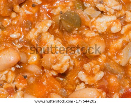 Making one pot stew with a tomato sauce base including ground turkey, chopped onions, chopped carrots and white beans.