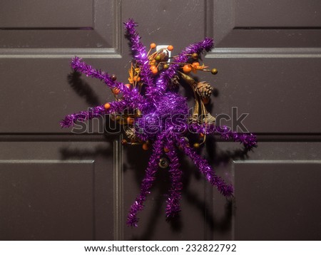 Purple sparkly spider decoration hanging on a door during Halloween