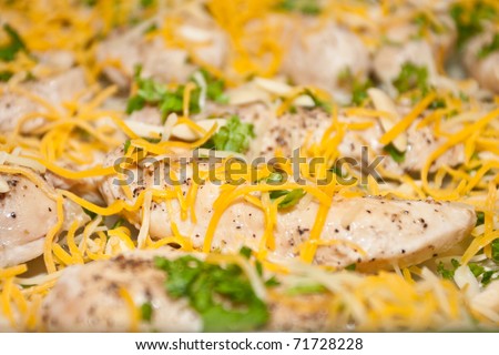 Oven baked tenderloin chicken stripes with parsley, almonds and shredded cheese.