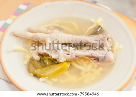 Chicken feet on a plate with chicken broth.