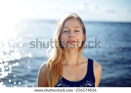 Close op of young woman posing on the beach against horizon