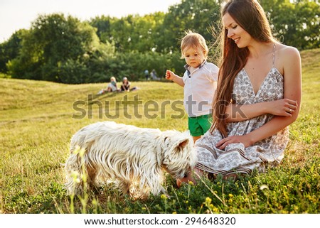 Mother with her son playing with a dog in the park