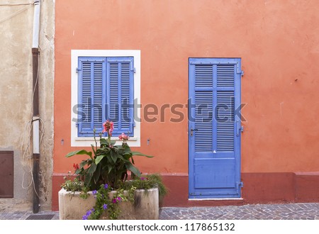 French wooden door and window in an orange wall