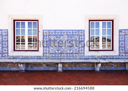 Wall with old Portuguese tiles, windows and a bench