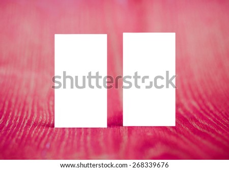Two vertical business card mockup over red wood background. Can be used for the presentation of the brand, company or person. Business card are clipped.