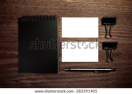 Two business card mockup over dark wood and pen with note. Can be used for the presentation of the brand, company or person. Business card are clipped. 90x50mm