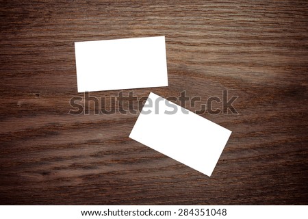 Two horizontal business card mockup over wood background. Can be used for the presentation of the brand, company or person. Business card are clipped. 90x50mm