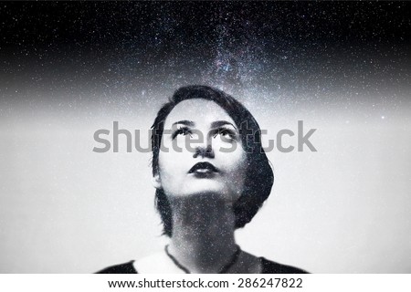 Double exposure portrait of attractive girl combined with photograph of star sky