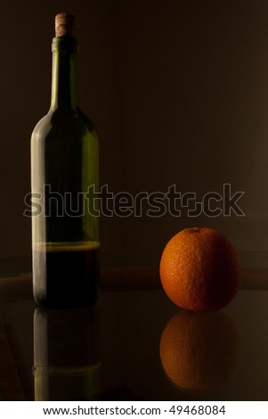 A bottle of wine and orange on the table for label