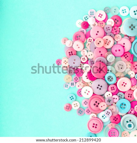 Collection of Colourful Sewing Buttons on Retro Turquiose Background with Copy Space