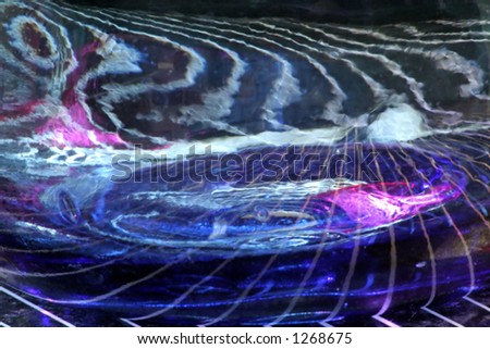 Abstract image of the bottom of a blue vase on top of a stripy surface.