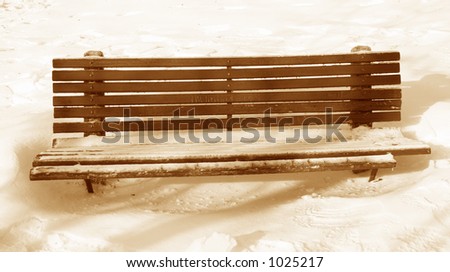 The old park bench covered in snow and ice