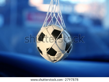 soccer ball hanging from a vintage car\'s mirror