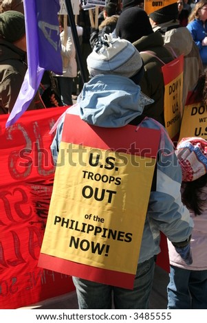 US troops out of the Philippines now protest little girl with sign on her hack protesting war and violence