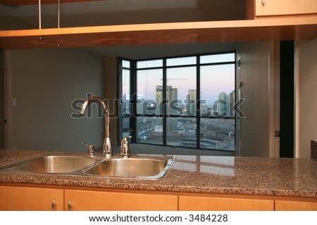 small condo apartment kitchen with sink and tap and marble counter tops