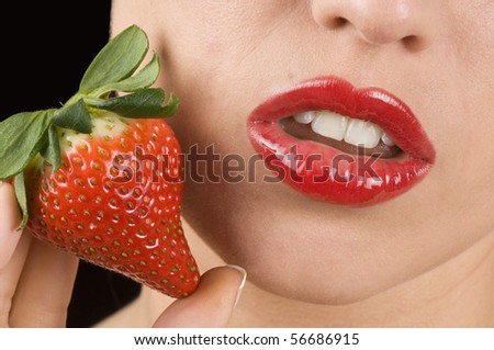 Macro of a beautiful lips and red strawberry