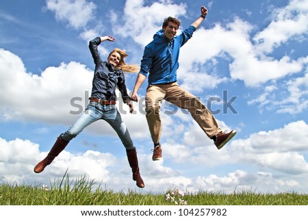 Young enthusiastic couple jumping up in the air