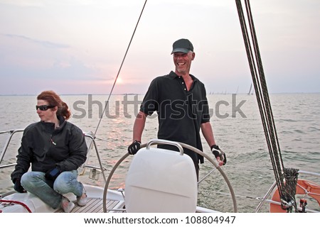 Happy sailor sailing at sunset on the IJsselmeer in the Netherlands