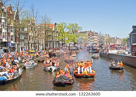 AMSTERDAM - APRIL 30: Amsterdam canals full of boats and people in orange during the celebration of queensday on April 30, 2012 in Amsterdam, The Netherlands