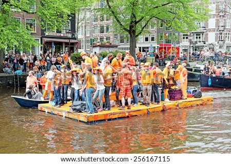 AMSTERDAM - APRIL 26: Canals of Amsterdam full of people in orange on boats during the celebration of kings day on April 26, 2014 in Amsterdam, The Netherlands