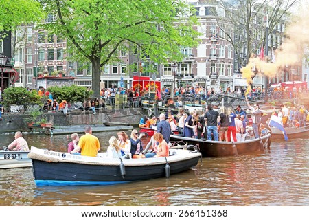 AMSTERDAM - APRIL 26: Canals of Amsterdam full of people in orange on boats during the celebration of kings day on April 26, 2014 in Amsterdam, The Netherlands
