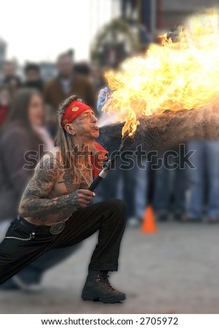 Street-art in Amsterdam: Man spitting fire on the Dam in Amsterdam Holland